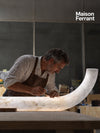 Un artisan sculpte une lampe en albâtre dans son atelier